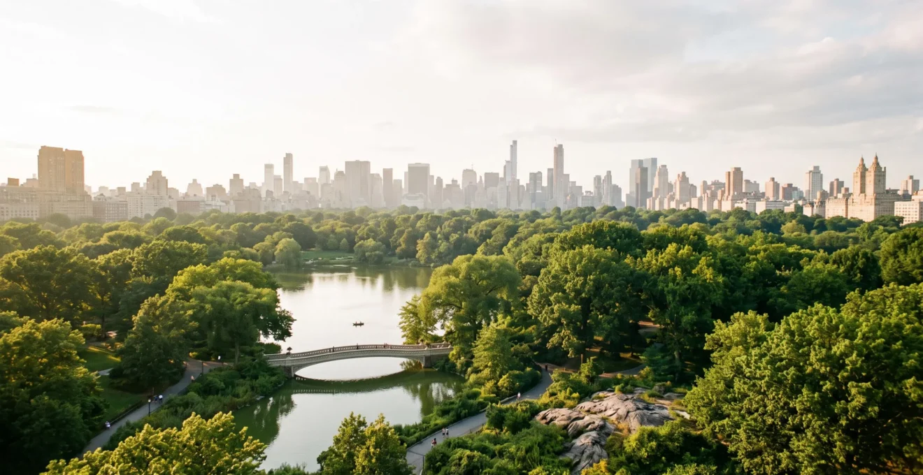 Panoramic golden-hour view over Central Park's meadows and lake with the Manhattan skyline in the background